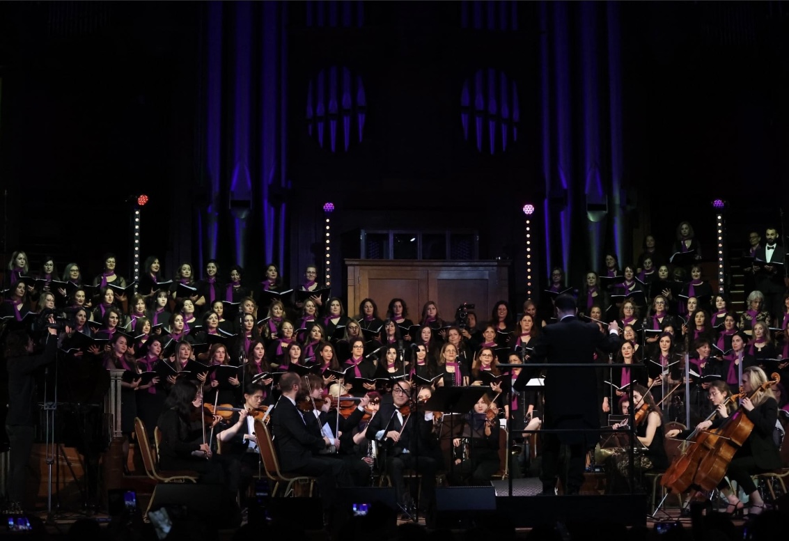 A choir and orchestra performing on stage