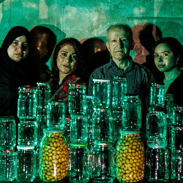 a group of people standing behind a collection of jars